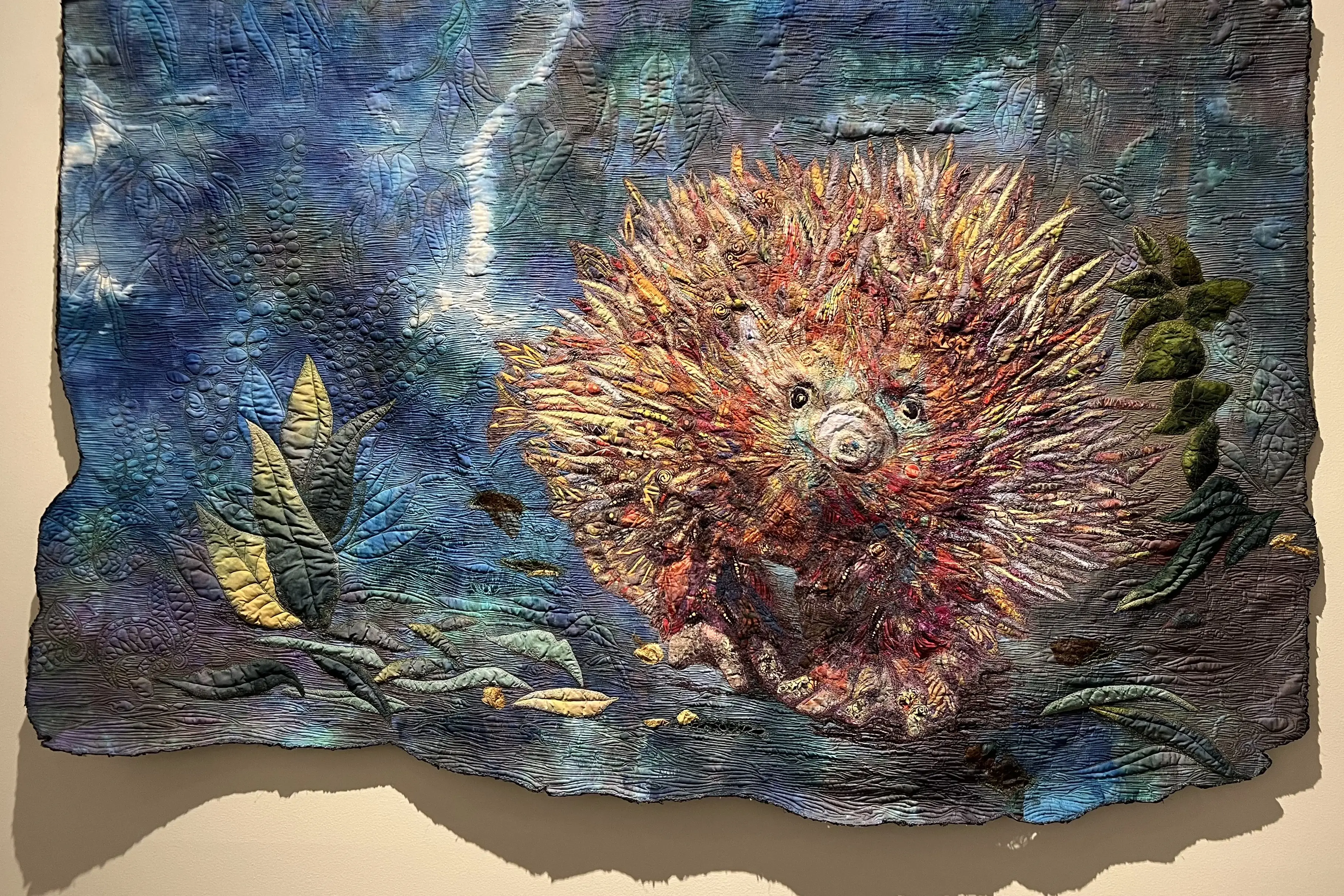  Sue de Vanny, 'Unguarded Moment', 2024. A collage of cotton fabrics: commercial printed fabrics and hand-dyed fabric on a hand-dyed background. Free motion thread painting and quilting. Yarn couched edging. 109 x 166cm.