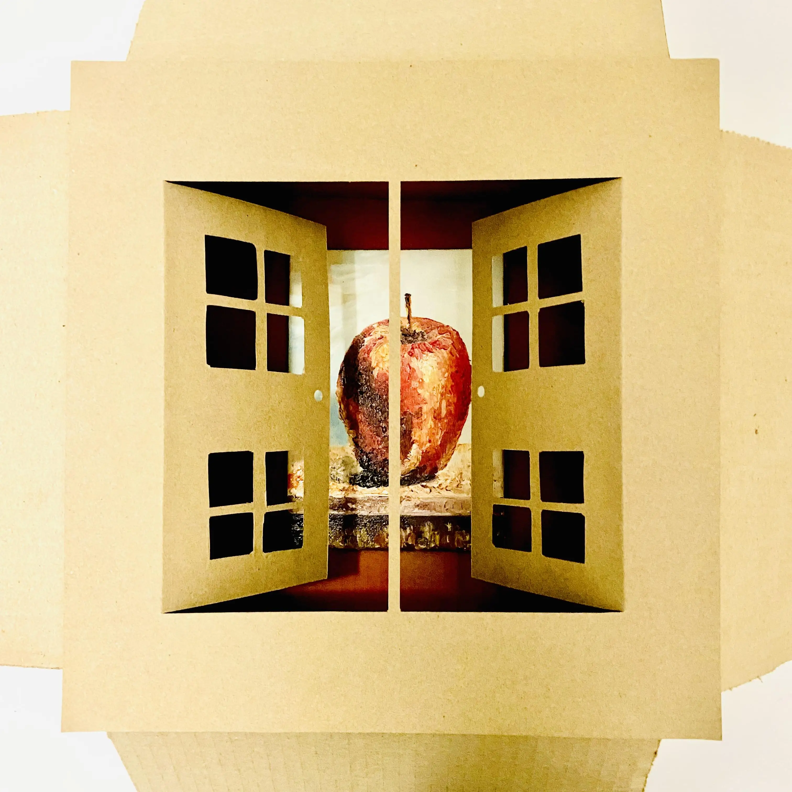 photo of box artwork with cut out doors and and painring of an apple behind them